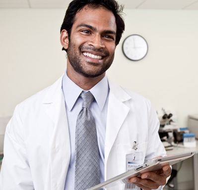 Doctor smiling and holding tablet