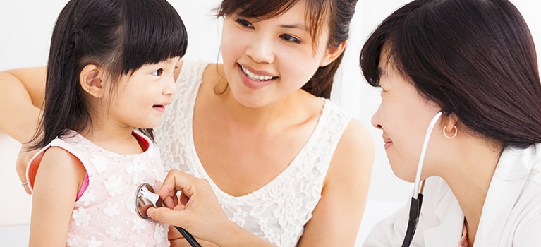 Asian doctor giving child examination