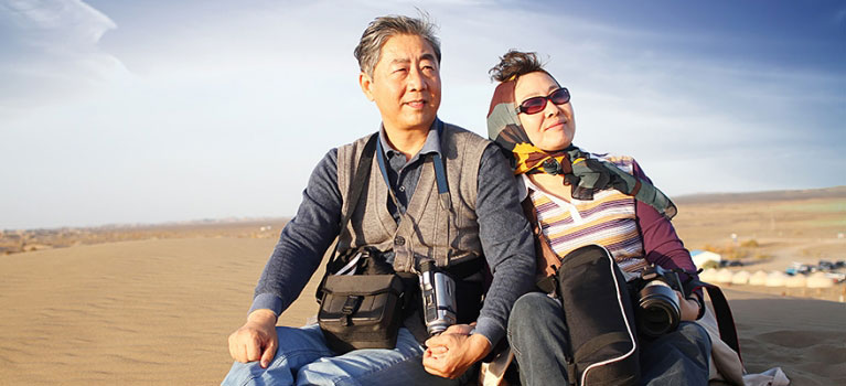 Travelling Asian couple on sand dune