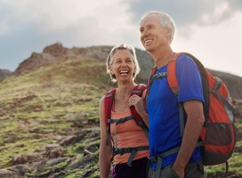 Senior couple hiking with backpakcs