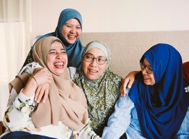 Muslim women sitting and laughing at home