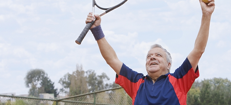 Excited senior man playing tennis
