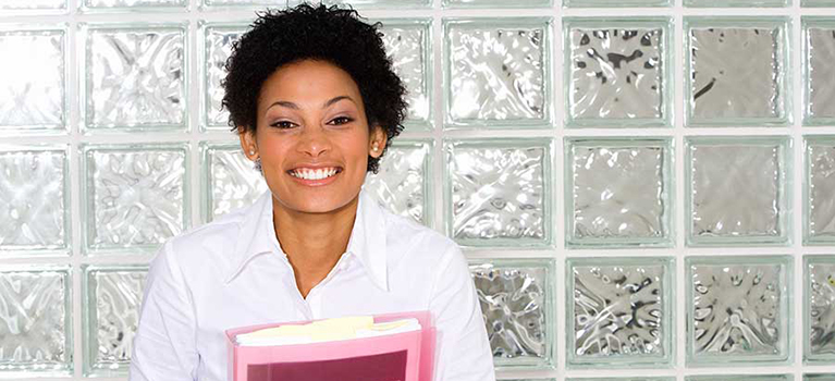 Young businesswoman smiling in front of glass wall