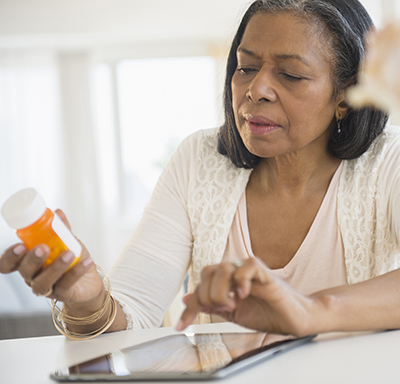 Middle-aged, mixed-race woman researching medication on her tablet