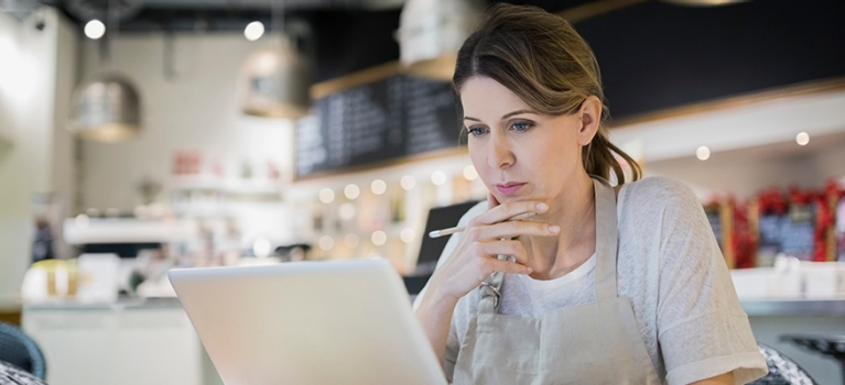 Businesswoman working at laptop in cafe