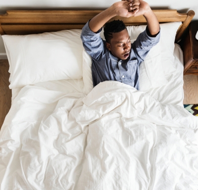 African-American man stretching and yawning as he awakens