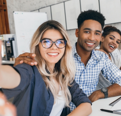 Young co-workers taking a selfie during a staff meeting