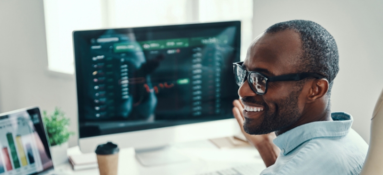 Smiling man with glasses at desk in office