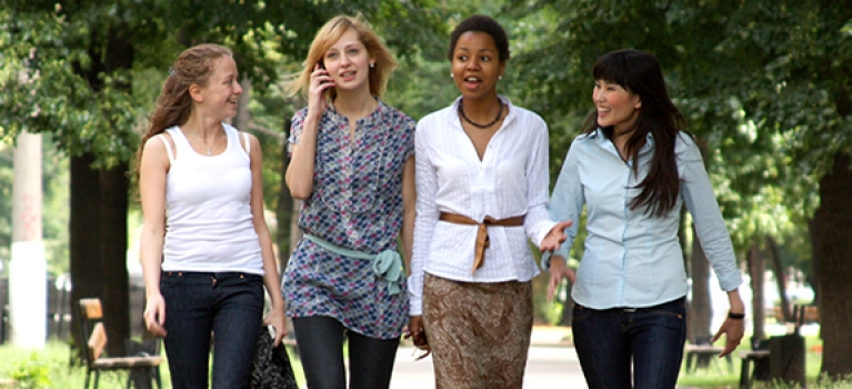 Four women walking through a city park