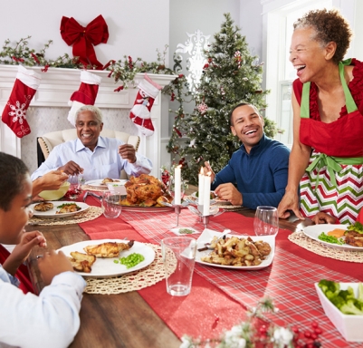 African-American family enjoying Christmas while sitting around a table
