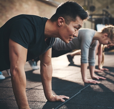 Group of men focused while doing push-ups in a gym