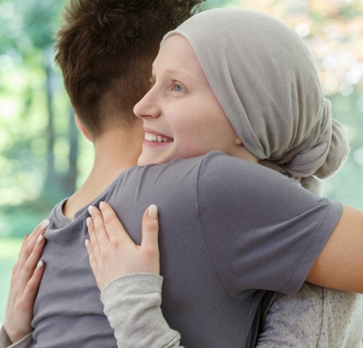 Female cancer patient being embraced by a loved one
