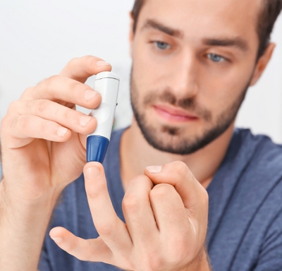 Adult male using a lancet to check blood sugar