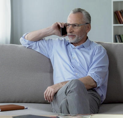 Middle-aged man on phone sitting on sofa