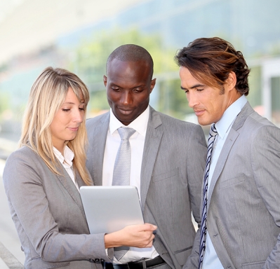 Businesswoman and businessmen looking at tablet