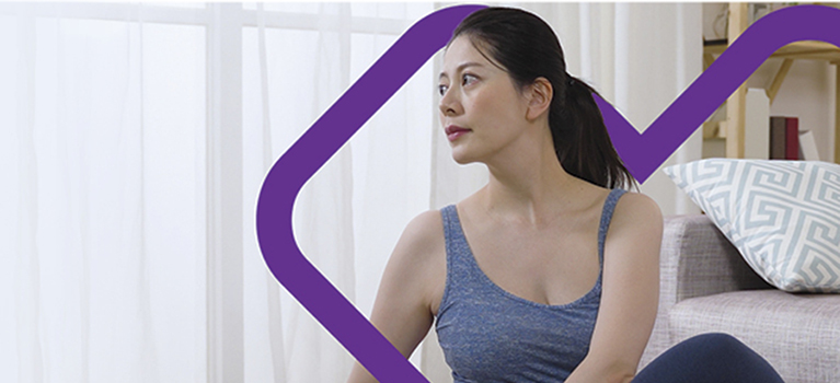 Woman sitting on floor with purple heart in the background