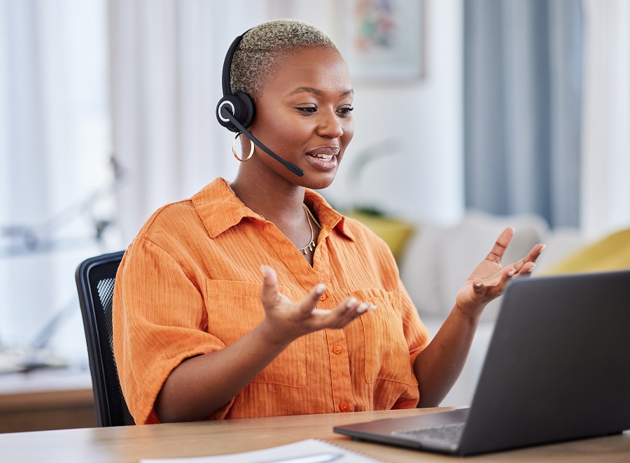 Woman in orange shirt looking at laptop