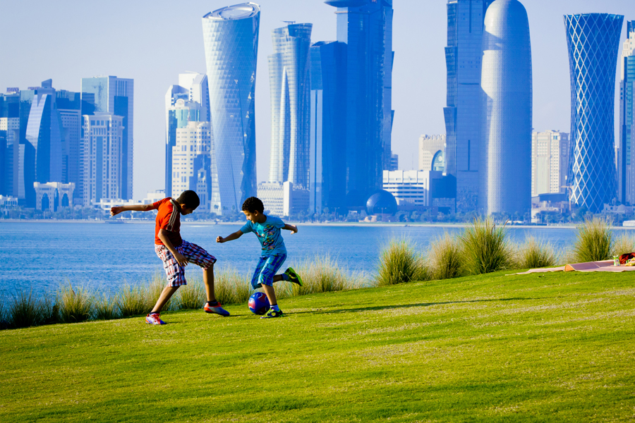 Two people kicking a ball on a field