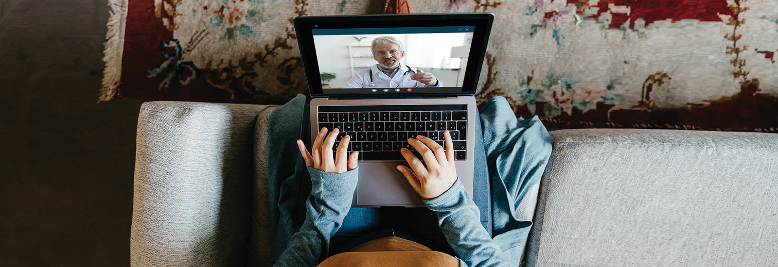 Woman on her laptop receiving a vHealth consultation from a doctor