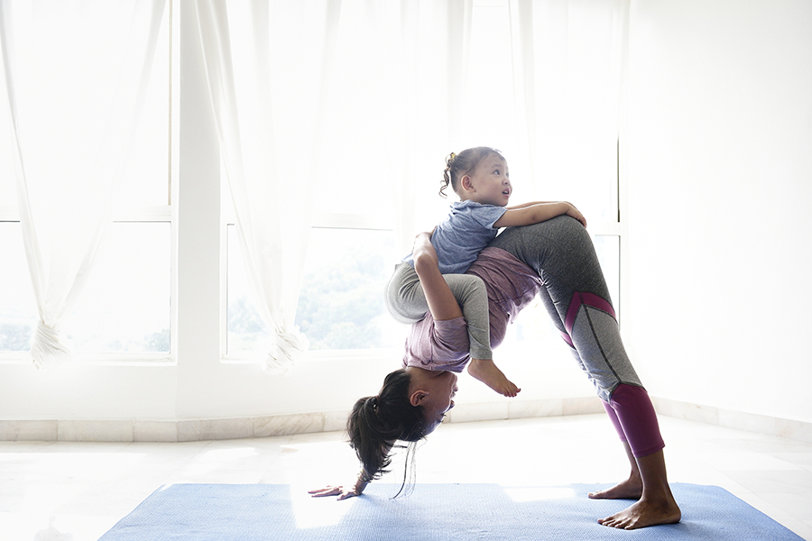 Woman doing yoga with baby on back
